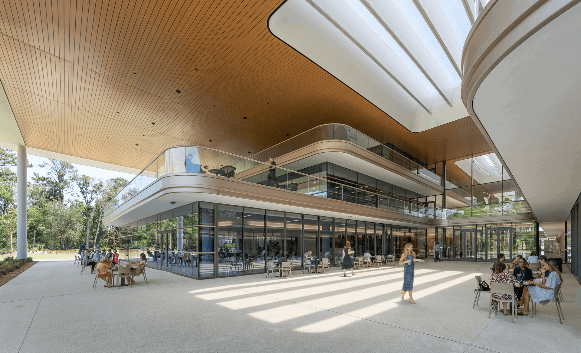 Modern commercial atrium with expansive glass storefront walls and high-traffic circulation space.