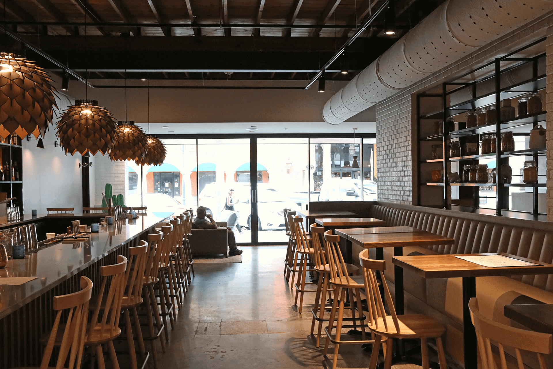 Restaurant interior with large sliding glass wall opening to the street.
